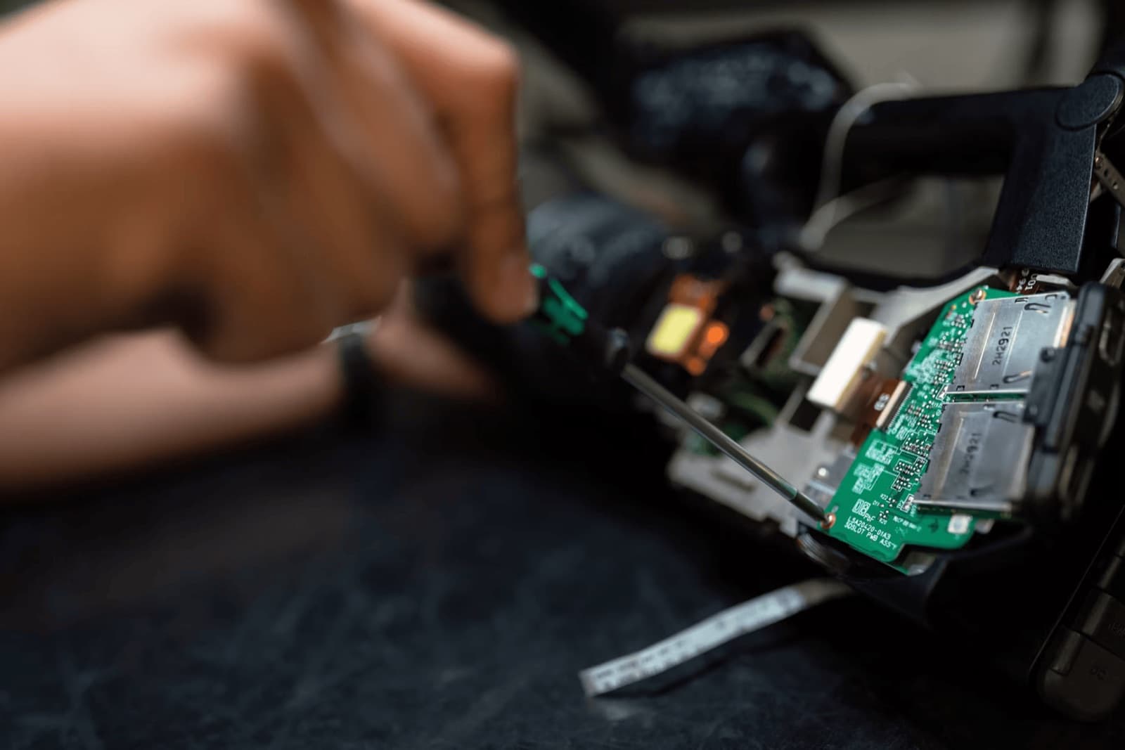 A technician's hands working on a circuit board