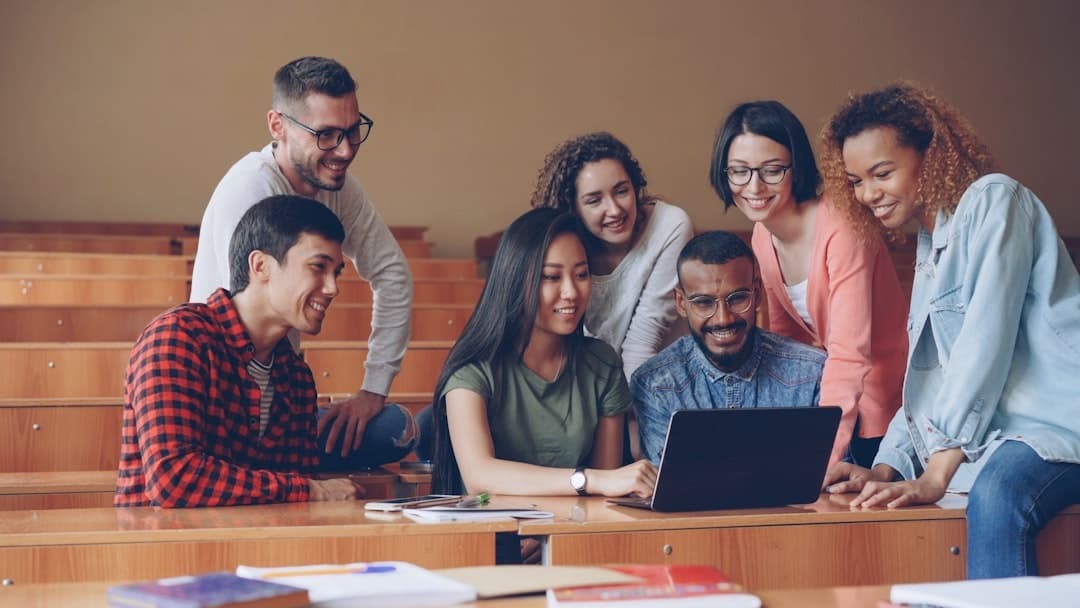 Emerging professionals gathered around a laptop, working through a problem together