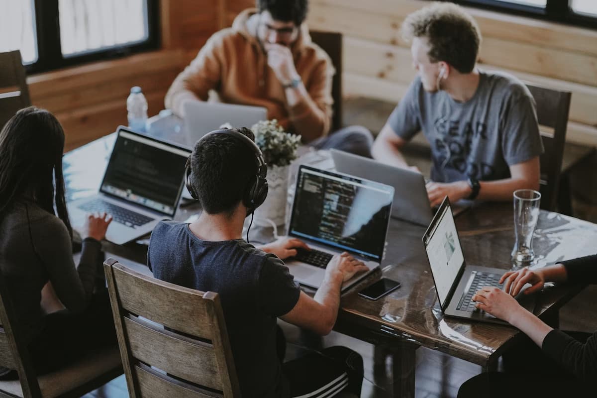 Emerging professionals working side by side on laptops at a shared table